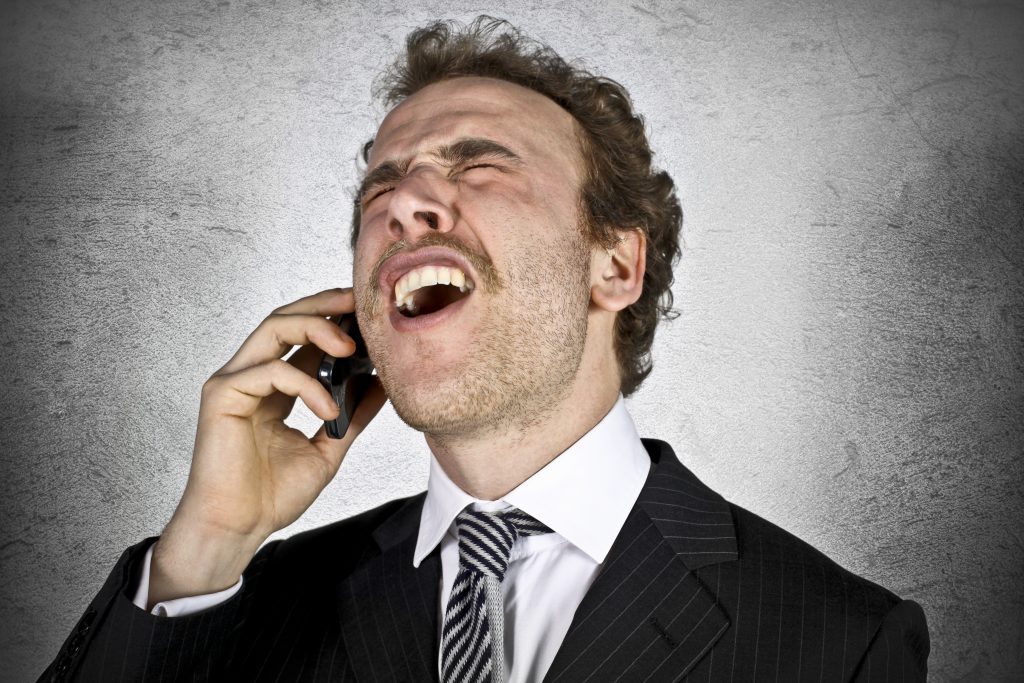 An image of an angry person who can’t hear anything over the phone